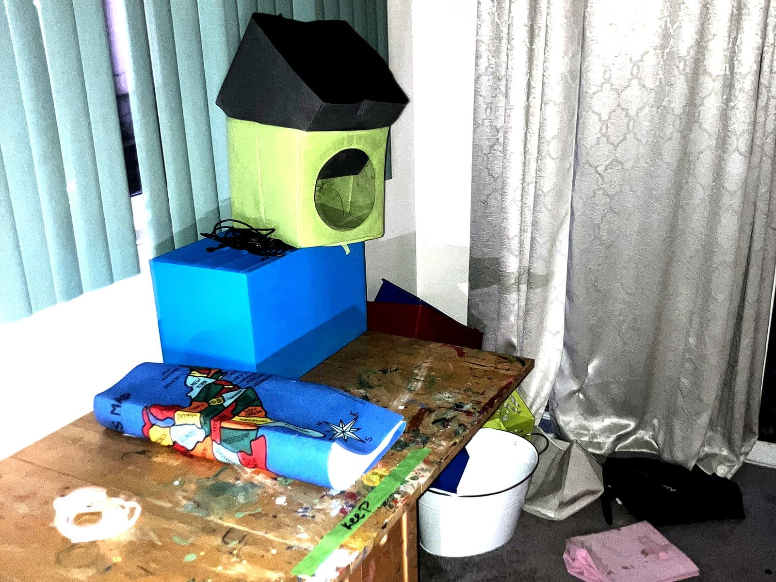 Room mid-move with a paint-marked table, storage boxes and items left out